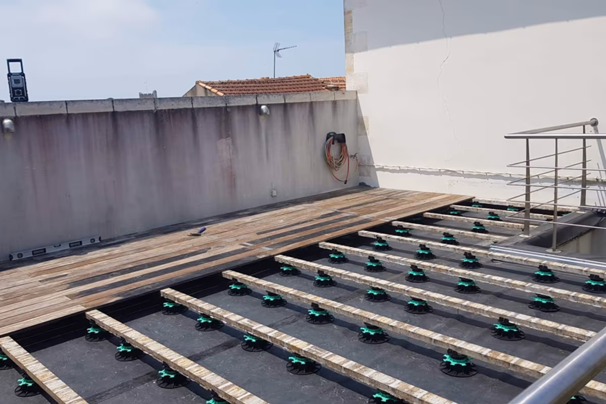 Lambourdes bois posées sur plots réglables au-dessus de la membrane EPDM du chantier de Fouras