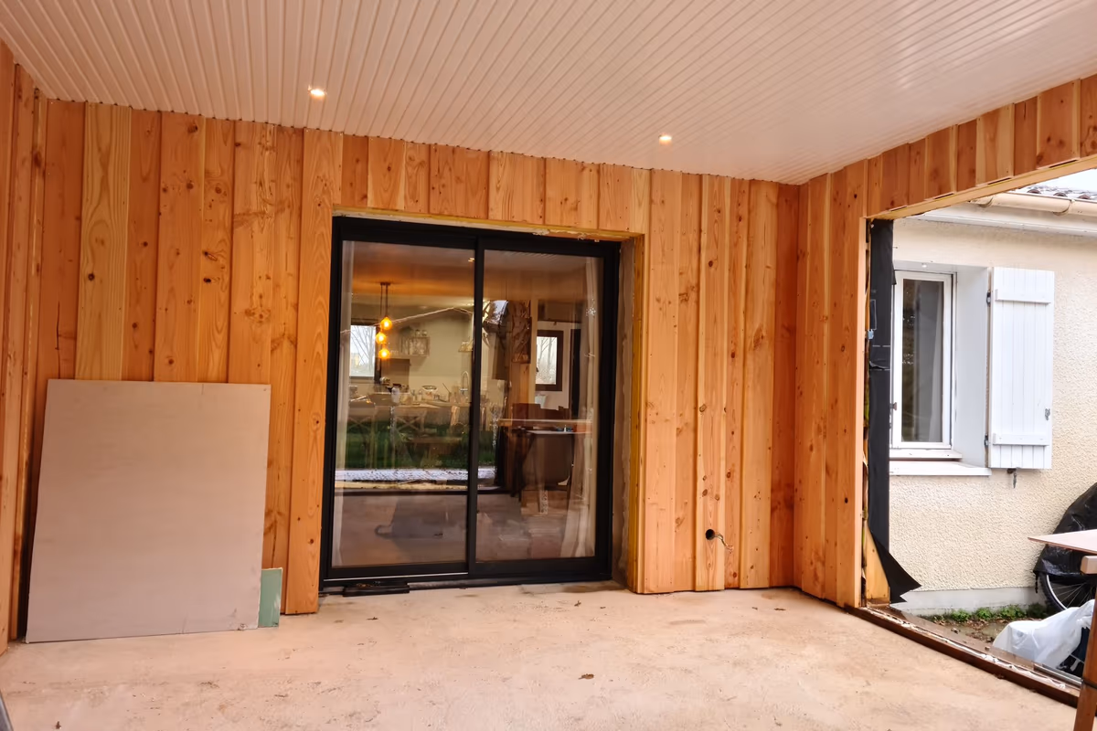 Intérieur d'une extension ossature bois avant second œuvre, ouverture de raccordement vers la maison existante