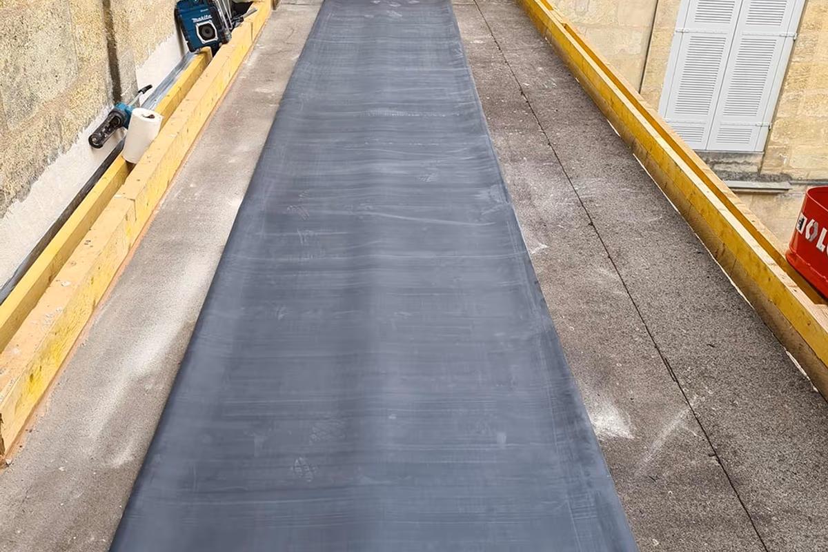 Membrane EPDM neuve déroulée sur le support béton du chantier de Bordeaux, avant collage