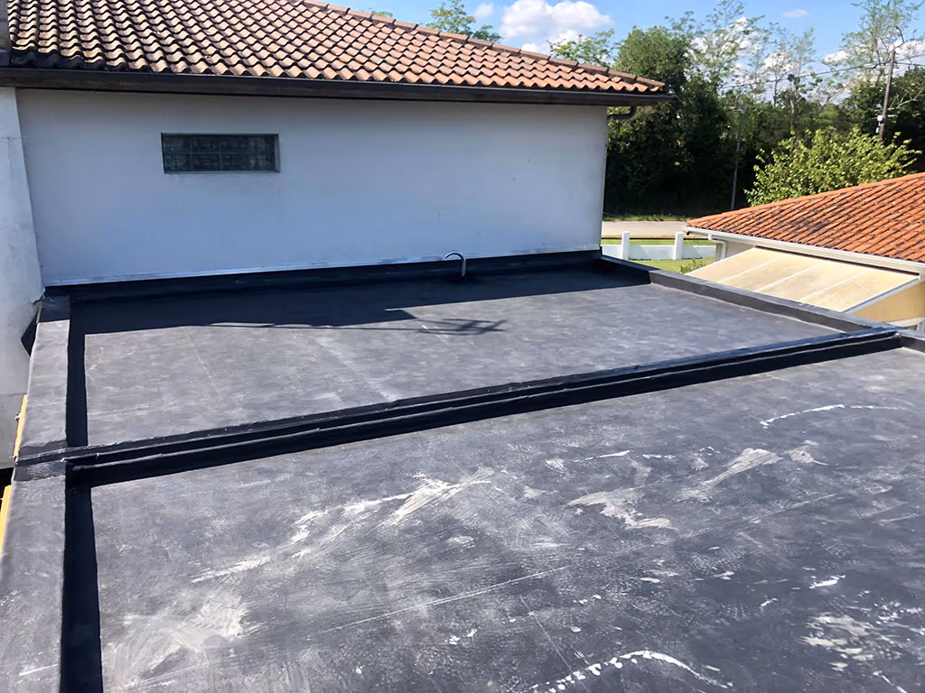 Bandes de jonction et relevés d'étanchéité sur le toit plat de Latresne, contre un mur et une couverture en tuiles