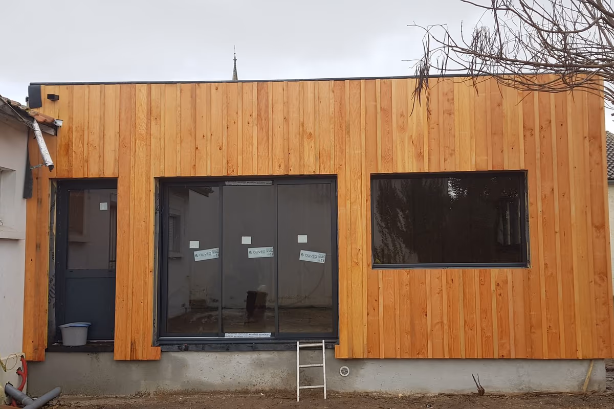 Extension bois à toit plat à Bordeaux, bardage vertical en bois naturel et acrotère fin, avant livraison