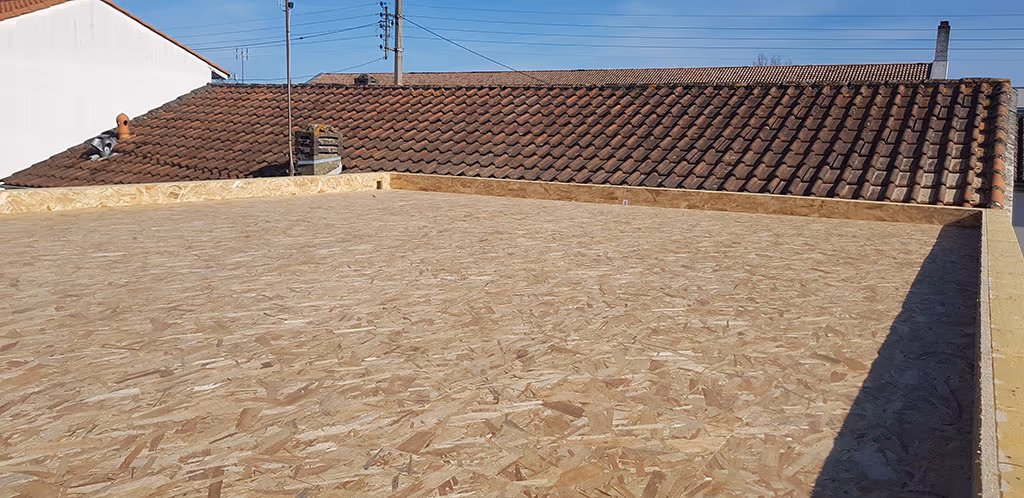 Support OSB d'un toit plat avec acrotère, avant étanchéité, entre des toitures en tuiles à Libourne