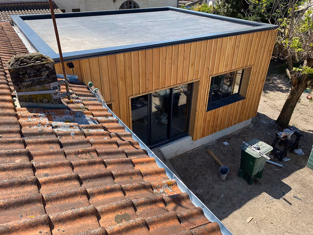 Toit plat à ossature bois réalisé à Lège-Cap-Ferret, bardage bois en façade et rive métallique autour de la toiture