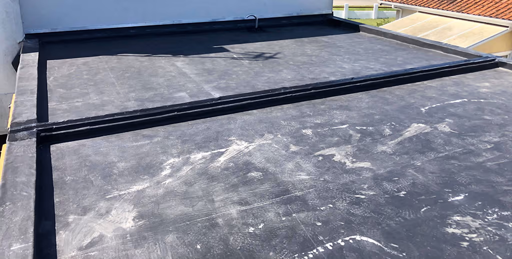 Relevés et bandes de jonction de la membrane d'un toit plat à Latresne, contre un mur enduit et un toit en tuiles